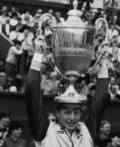 Boris Becker tennis holding the Wimbledon Trophy on top of his head after becoming Boris Becker tennis holding the Wimbledon Trophy on top of his head after becoming