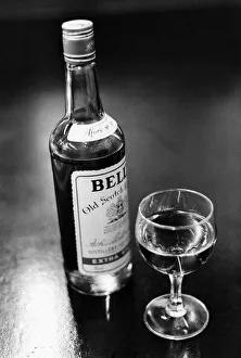 A bottle of Bells whisky and a poured glass beside it. April 1983 P009582 A bottle of Bells whisky and a poured glass beside it. April 1983 P009582