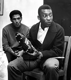 Brazilian football star Pele looking at a pair of football boots as team mate Garrincha Brazilian football star Pele looking at a pair of football boots as team mate Garrincha