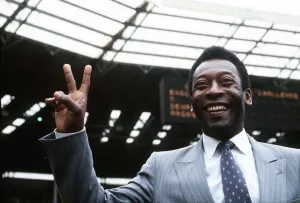 Brazillian football legend Pele gives the peace sign while standing on the pitch at Brazillian football legend Pele gives the peace sign while standing on the pitch at