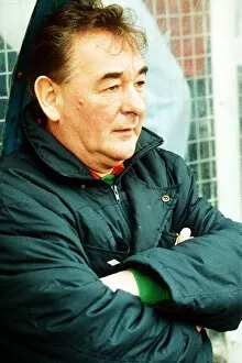 Brian Clough football manager sitting on team bench in football jacket with arms folded