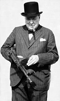 Expressions Gallery: British Prime Minister Winston Churchill holding a Thompson submachine gun whilst smoking