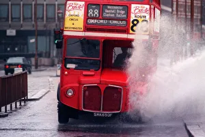 A bus splashing through a large puddle of water after a heavy rainfall in London A bus splashing through a large puddle of water after a heavy rainfall in London
