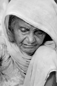 Cataracs dim the eyes of the old flower seller who sits at the enterance of Gandi' Cataracs dim the eyes of the old flower seller who sits at the enterance of Gandi'