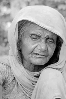 Cataracs dim the eyes of the old flower seller who sits at the enterance of Gandi'