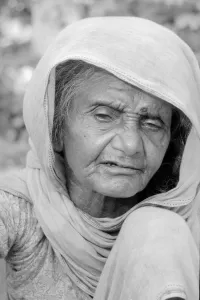 Cataracs dim the eyes of the old flower seller who sits at the enterance of Gandi' Cataracs dim the eyes of the old flower seller who sits at the enterance of Gandi'