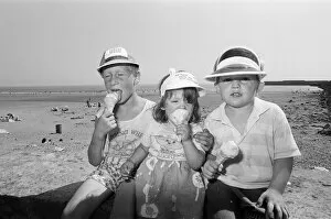 Children enjoy an ice cream as they try to keep cool on Coney Beach in Porthcawl