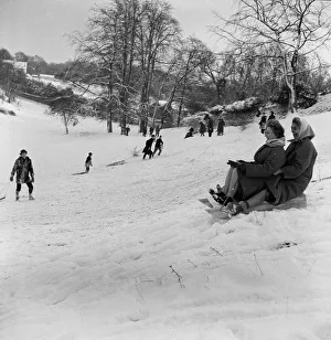 Why should the children only have fun, as two women take part in sledging in Stoke Park Why should the children only have fun, as two women take part in sledging in Stoke Park