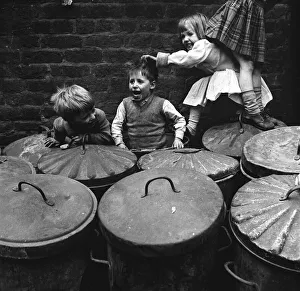 Children playing dustbins on a slum housing estate 1st June 1962 Children playing dustbins on a slum housing estate 1st June 1962