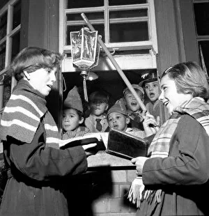 Children singing Christmas carols with a hanging lantern