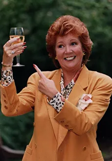 Cilla Black holding glass of wine wearing gold jacket and spotted blouse Cilla Black holding glass of wine wearing gold jacket and spotted blouse