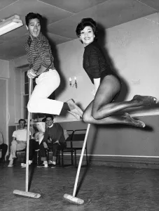 Cliff Richard Actor / Singer with Carole Gray dancing with broom sticks Cliff Richard Actor / Singer with Carole Gray dancing with broom sticks