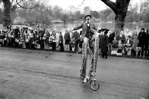 A clown stilt walker seen here riding a oversize bicycle in the Easter parade A clown stilt walker seen here riding a oversize bicycle in the Easter parade