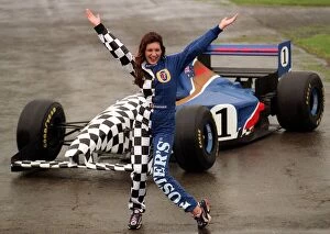 Images Dated 31st May 1998: Coping with the wind and rain, model Kelly Brook is pictured with Fosters Formula One car
