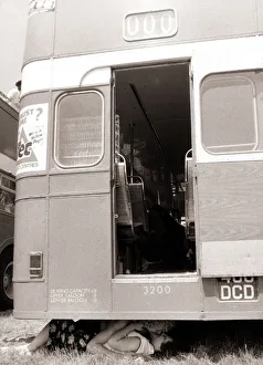 A couple enjoy the shade and privacy of a double decker bus as they kiss A couple enjoy the shade and privacy of a double decker bus as they kiss