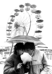 Couple sharing candyfloss under an unmbrella in a wet Southend. 8th April 1985 Couple sharing candyfloss under an unmbrella in a wet Southend. 8th April 1985