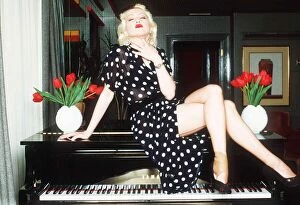 Cyndi Lauper Singer Actress sitting in top of grand piano in black