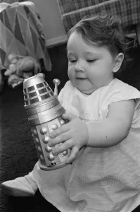 00511 Gallery: The daughter of Raymond Cusick designer of the Daleks from Doctor Who playing with a toy