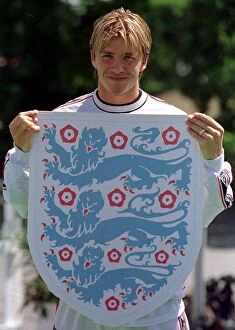 Images Dated 17th June 1998: David Beckham holds up the three lions badge June 1998 during a England training