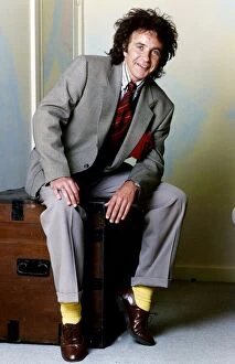Images Dated 31st May 1989: David Essex Singer sitting on a blanket box wearing a suit and yellow socks