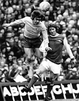 David Nish of Derby County heads the ball from Alan Ball of Arsenal during their league