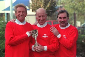 Denis Law with Bobby Charlton and George Best hold 1966 World Cup replica Denis Law with Bobby Charlton and George Best hold 1966 World Cup replica