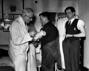 Doctor administering anti flu vaccinations to workers at a Petrochemicals factory Doctor administering anti flu vaccinations to workers at a Petrochemicals factory