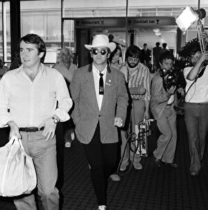 Dressed in a stetson hat, Elton John leaves Heathrow Airport for America