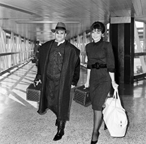 Elton John with his wife Renate arriving from Los Angeles at London Airport