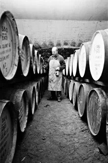 Images Dated 16th July 2014: An employee of the Knockando Whisky Distillery checks the casks in the bonded warehouse