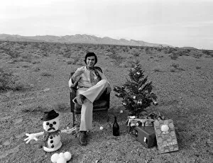Engelbert Humperdinck sitting in a chair with a Christmas tree