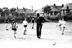 Images Dated 23rd July 1980: Former England footballer Bobby Moore coaches children at the Coral sponsored Bobby Moore