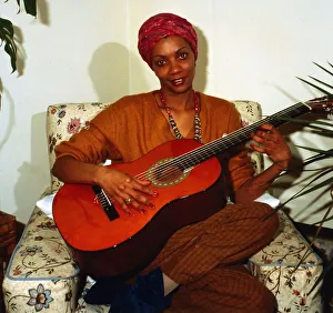 Eva Mottley sitting on chair playing guitar April 1983 Eva Mottley sitting on chair playing guitar April 1983