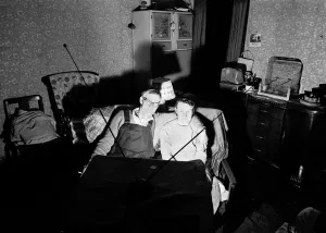 A evening in for a husband and wife watching a coin-operated television A evening in for a husband and wife watching a coin-operated television