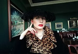 Images Dated 29th November 1996: Evita Fashion Model sitting down black coat with leopard skin collar feather hat black