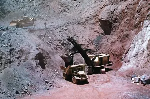 Excavator loads Iron-ore into lorry at Mine, Cassinga Angola Excavator loads Iron-ore into lorry at Mine, Cassinga Angola
