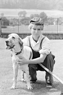 Felicity Kendal dressed as a gardener with a dog July 1982 whilst filming a new
