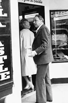 Images Dated 15th May 1975: Frank Sinatra following barbara marx into a shop