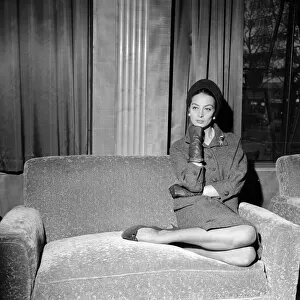 Images Dated 2nd December 2014: French film actress Capucine poses sitting on a sofa at the Odeon in Leicester Square