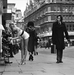 A gentlman admires model Christine Donnas behind as she searches out a new pair of