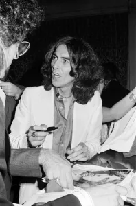 George Harrison signs posters for his new album 'Thirty Three & 1/3' George Harrison signs posters for his new album 'Thirty Three & 1/3'