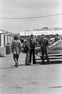 George Harrison walking past some photographers at the British Grand Prix motor racing George Harrison walking past some photographers at the British Grand Prix motor racing