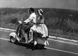 Girl riding sidesaddle on a scooter during a trip in the Italian countryside Girl riding sidesaddle on a scooter during a trip in the Italian countryside