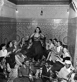 Related Images Collection: A group of French actresses enjoy a performance by a local belly dancer during a night