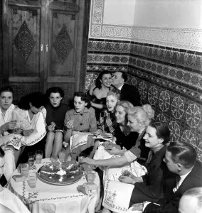 A group of friends gathered around a table enjoying drinks on a night out in Marrakech A group of friends gathered around a table enjoying drinks on a night out in Marrakech