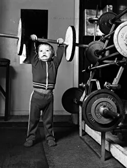 Images Dated 3rd February 1981: Two and half year old boy Ian Page lifts a set odf special wooden weights built for him