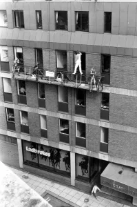 No health and safety here as this painter stands precariously on top of the hand rails of No health and safety here as this painter stands precariously on top of the hand rails of