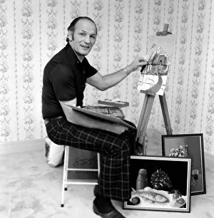 Henry Cooper working on a painting of a Cotswold Cottage. January 1977 77-00066-001