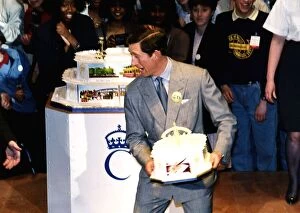 Images Dated 14th November 1988: HRH Prince Charles about to throw a birthday cake to a crowd of onlookers during his