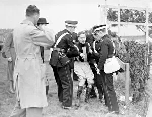 Grand National Gallery: Injured jockey R Curran (Ulster Monarch) is helped to his feet in The Grand National